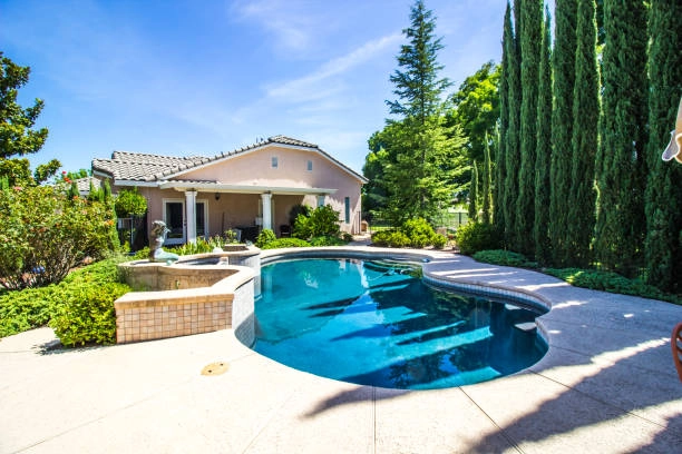 outdoor pool with pine trees and house -pool remodel