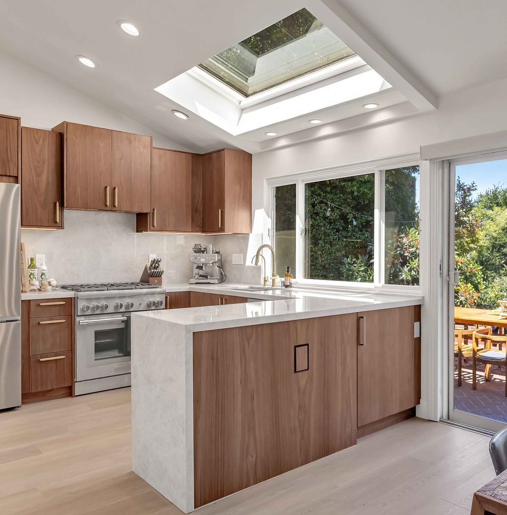 Remodeled kitchen with wood cabinetry, a skylight and sliding doors to the backyard
