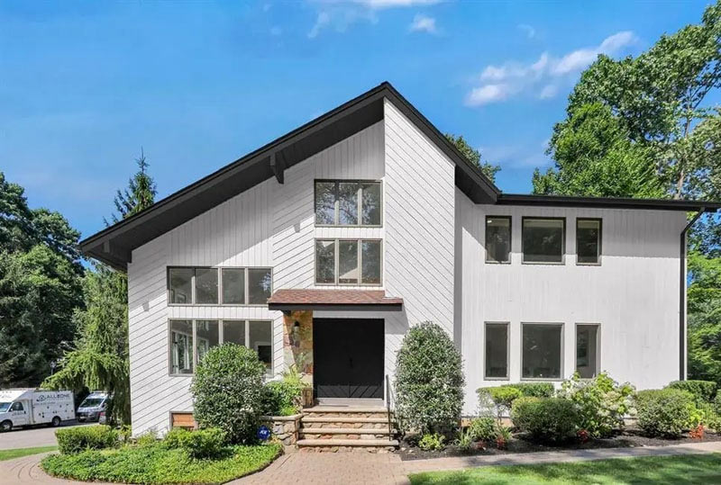 Two-story home in the Bay Area with white siding, dark rooflines and a covered front entrance