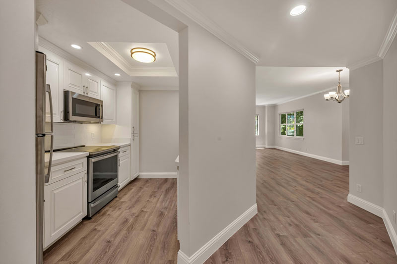 Renovated apartment interior with a white kitchen and wood-look flooring